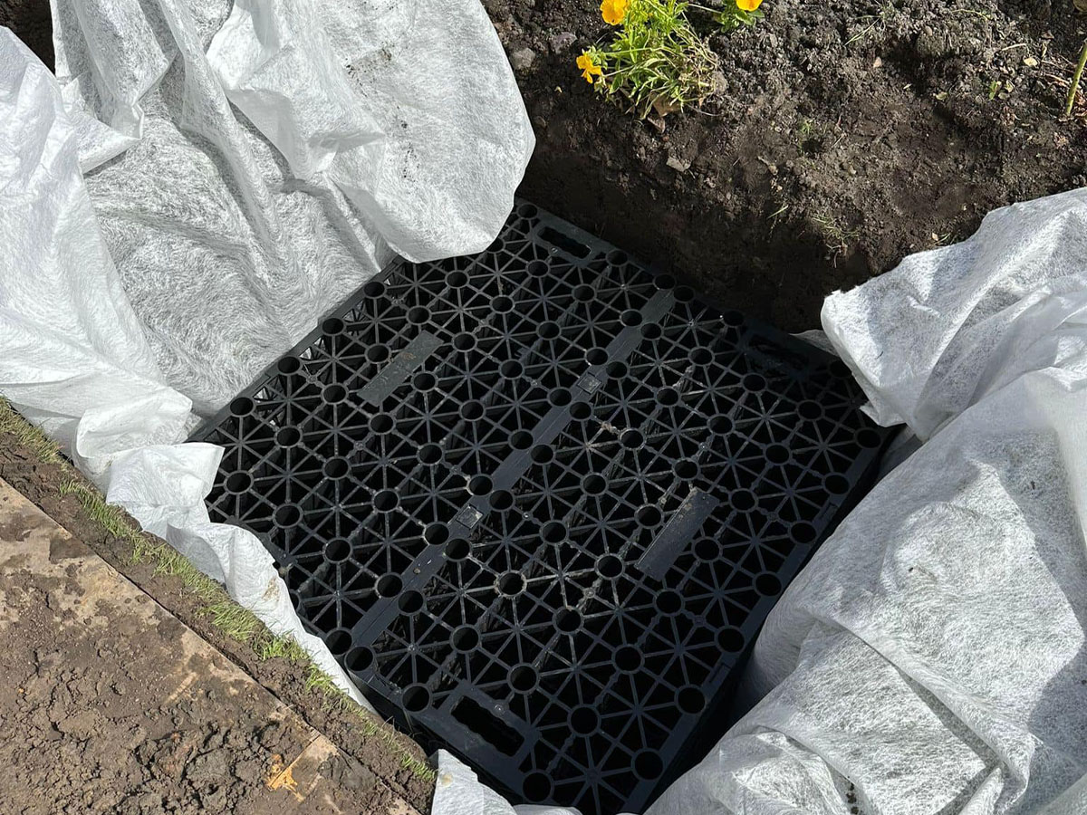 Drainage engineers installing soakaway crates and geotextile membrane in London